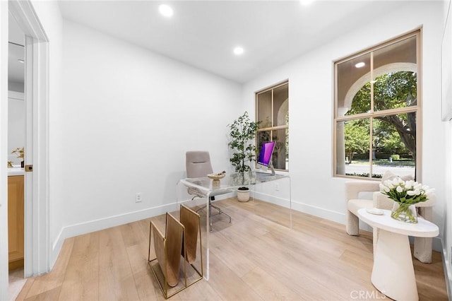 home office with light hardwood / wood-style floors