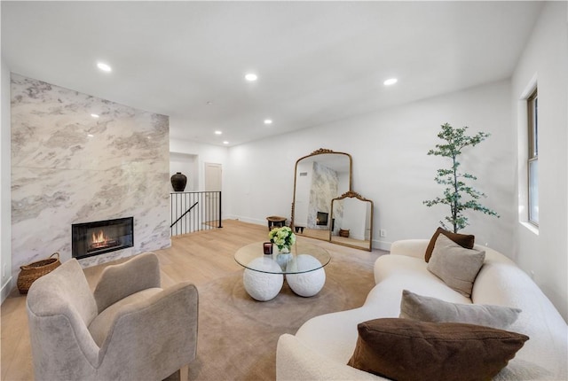 living room featuring light wood-type flooring and a high end fireplace