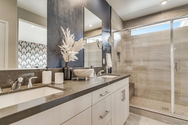 bathroom featuring tile patterned floors, vanity, and a shower with door