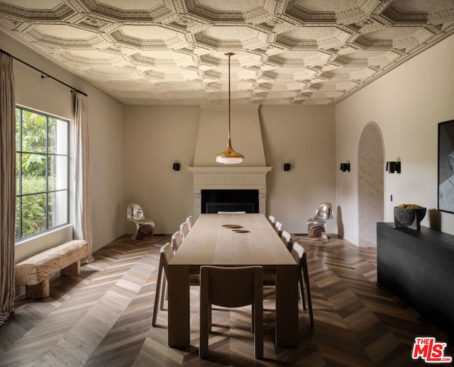 dining space featuring parquet flooring and a large fireplace