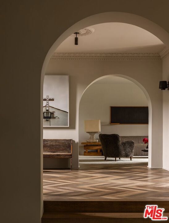 corridor featuring wood-type flooring and ornamental molding