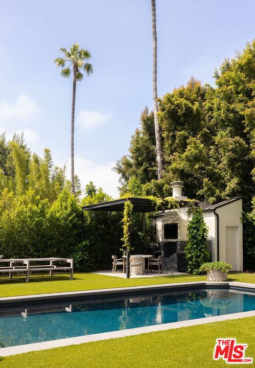 view of swimming pool featuring an outdoor structure and a lawn