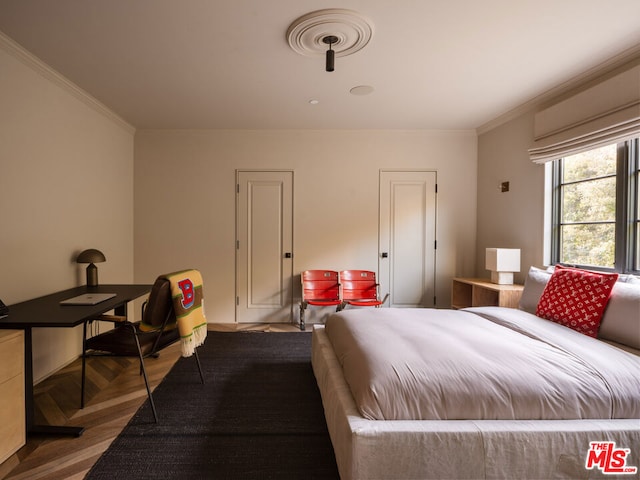 bedroom featuring ornamental molding and light parquet flooring