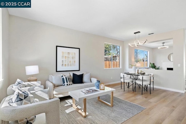 living room featuring a chandelier and light wood-type flooring