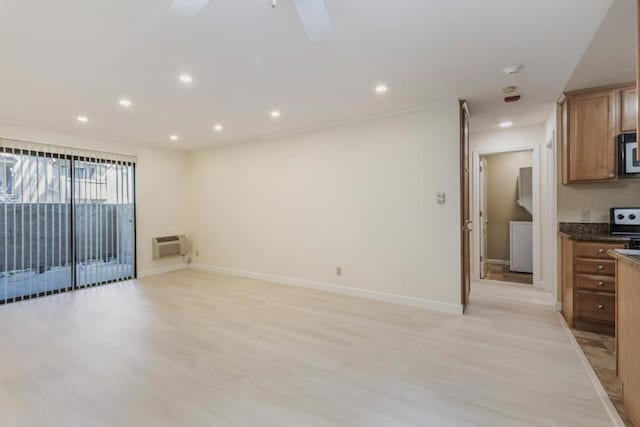 interior space with ceiling fan, an AC wall unit, and light wood-type flooring