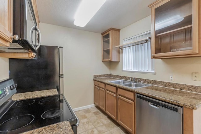 kitchen featuring stone countertops, appliances with stainless steel finishes, sink, and a textured ceiling