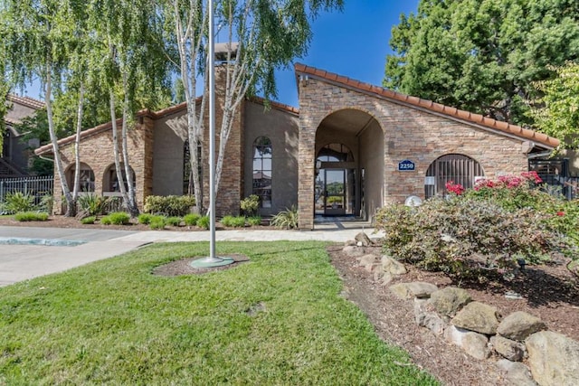 mediterranean / spanish home featuring a front lawn