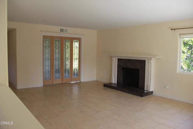 unfurnished living room featuring a high end fireplace