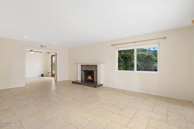 unfurnished living room with ceiling fan and a premium fireplace