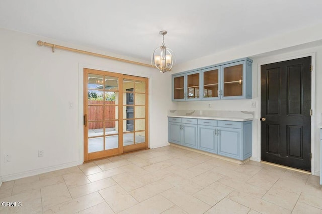 kitchen featuring blue cabinetry, decorative light fixtures, and a notable chandelier