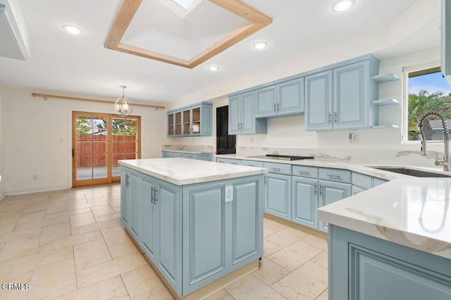 kitchen with a center island, sink, blue cabinetry, and decorative light fixtures