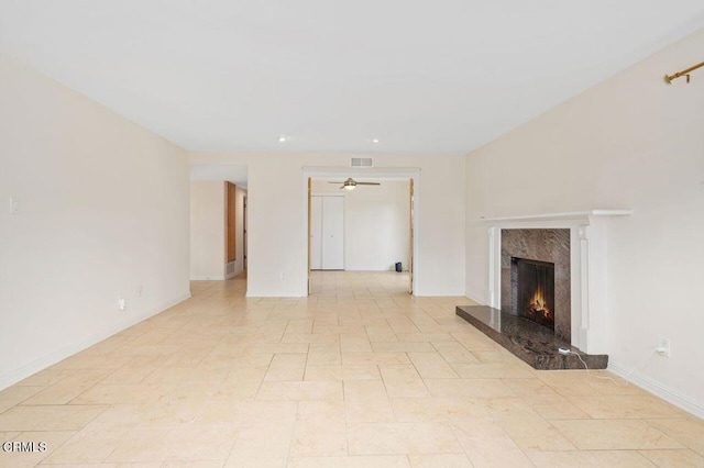 unfurnished living room featuring ceiling fan and a fireplace