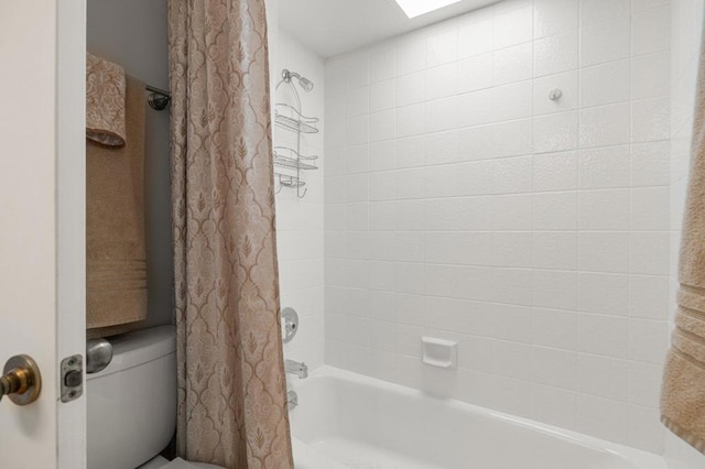 bathroom with a skylight, toilet, and shower / bath combo with shower curtain