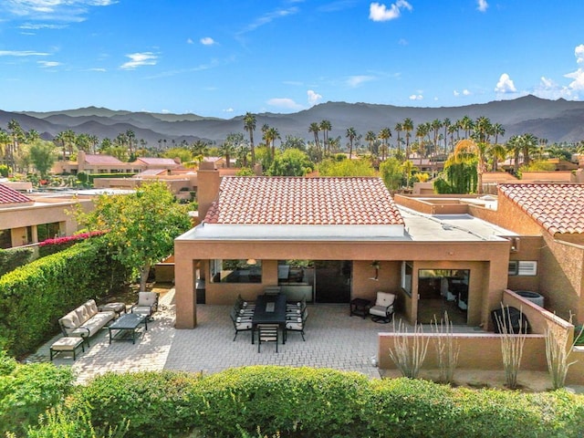 rear view of house featuring a mountain view, a patio area, and outdoor lounge area