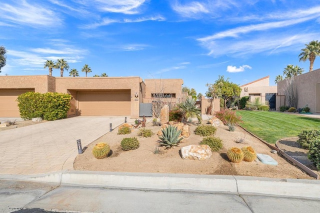 pueblo revival-style home featuring a garage and a front yard