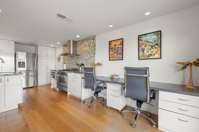 home office with sink and light wood-type flooring