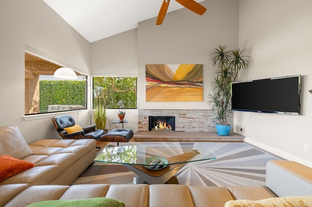 living room with a stone fireplace and vaulted ceiling