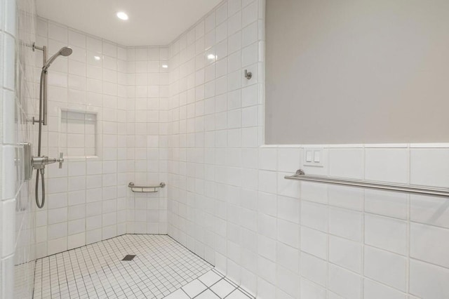 bathroom with tiled shower and tile walls