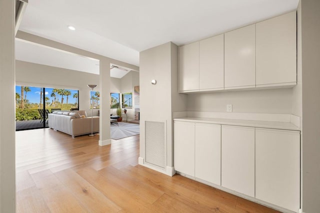 interior space with plenty of natural light, vaulted ceiling, and light wood-type flooring