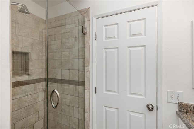 bathroom with vanity and tiled shower