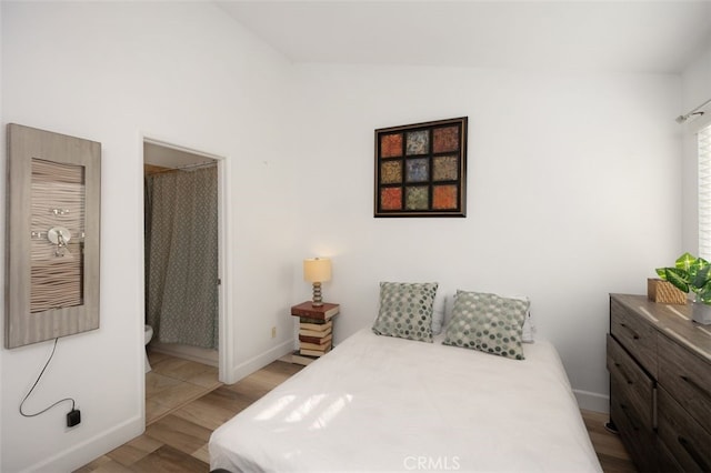 bedroom with lofted ceiling and light wood-type flooring