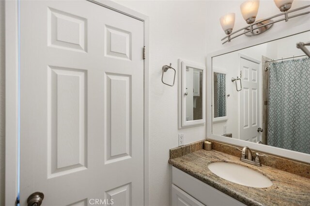 bathroom featuring a shower with curtain and vanity