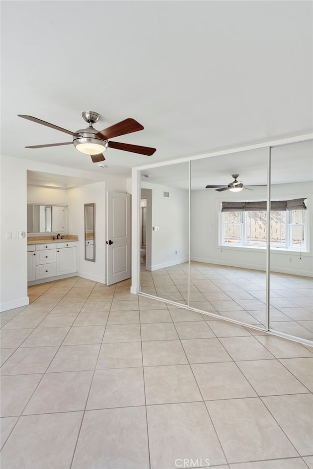 tiled spare room featuring ceiling fan