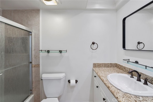 full bathroom with enclosed tub / shower combo, vanity, and toilet