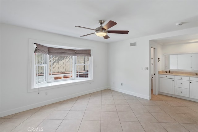 tiled empty room featuring ceiling fan and sink