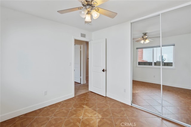 unfurnished bedroom with ceiling fan, tile patterned floors, and a closet