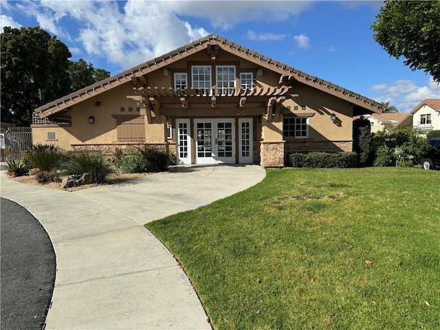 view of front facade featuring french doors, a front yard, and a pergola