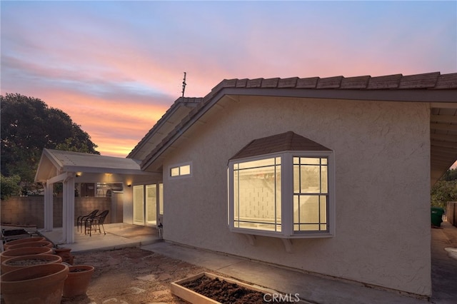 property exterior at dusk with a patio