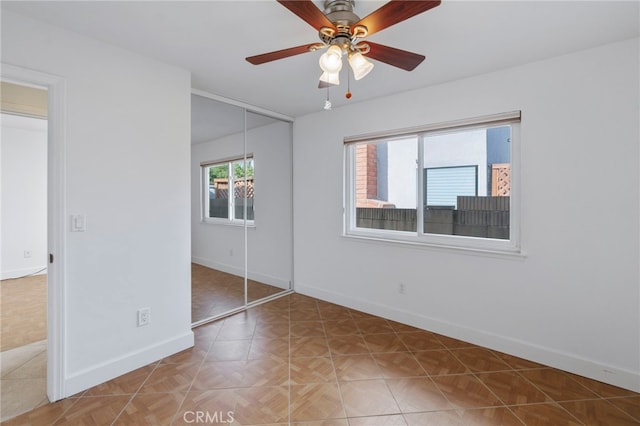 unfurnished bedroom featuring parquet flooring, ceiling fan, and a closet