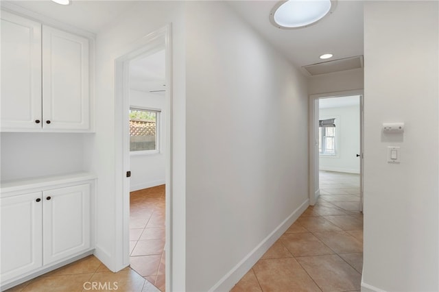 corridor with a healthy amount of sunlight and light tile patterned floors