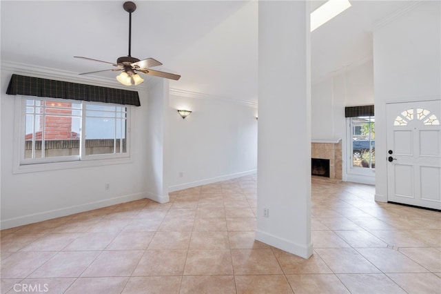 interior space with light tile patterned flooring, ceiling fan, a fireplace, and high vaulted ceiling