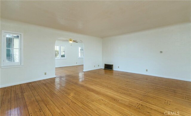 empty room with ceiling fan and light hardwood / wood-style floors