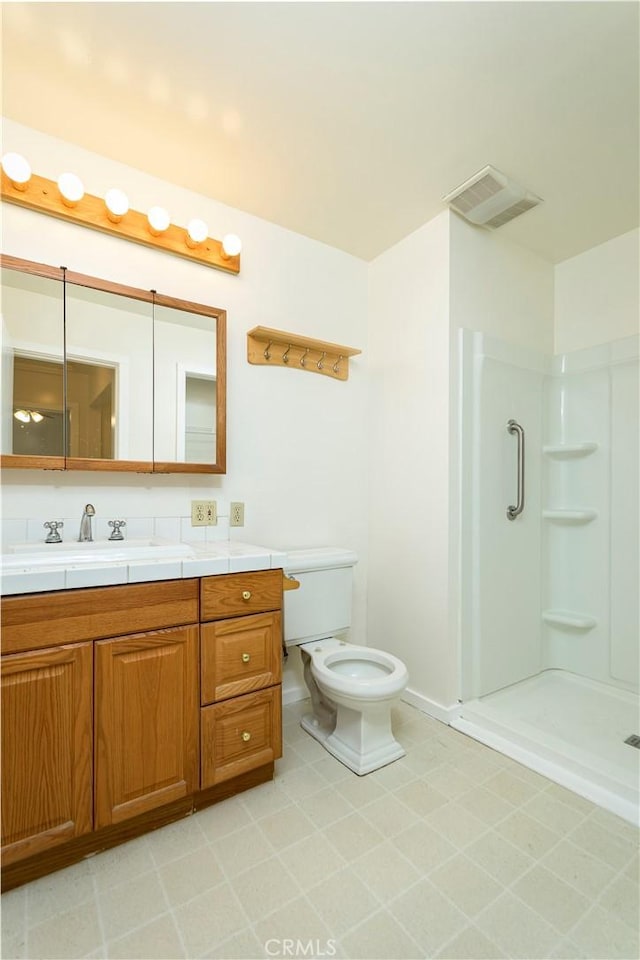 bathroom featuring vanity, toilet, and a shower