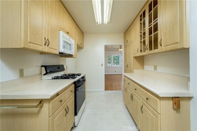 kitchen featuring range with gas cooktop, ceiling fan, and light brown cabinets