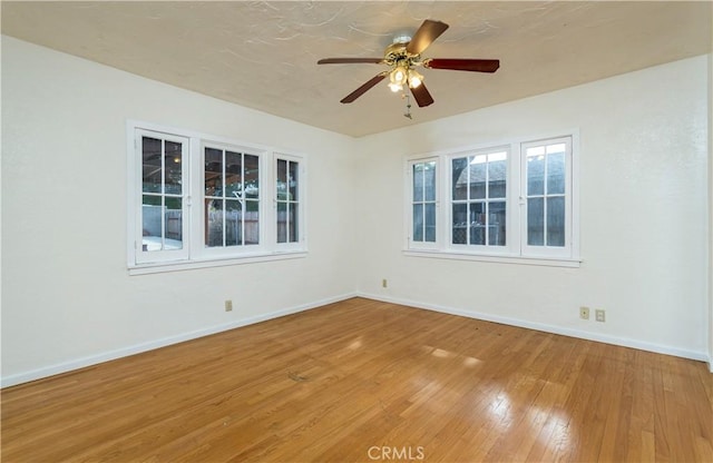 spare room featuring wood-type flooring and ceiling fan