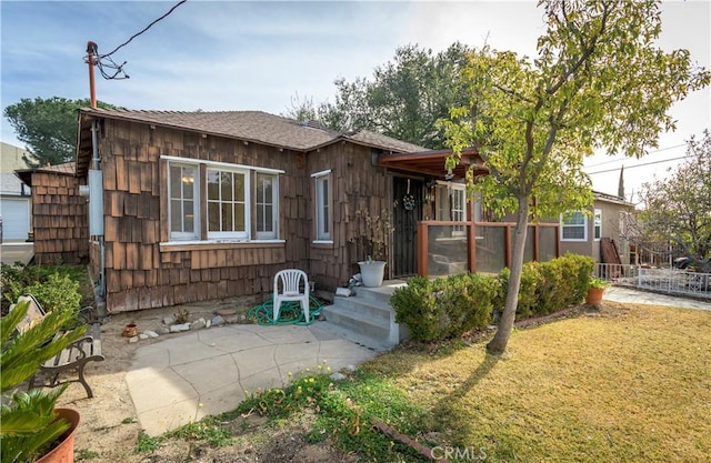 view of front of house featuring a front lawn and a patio