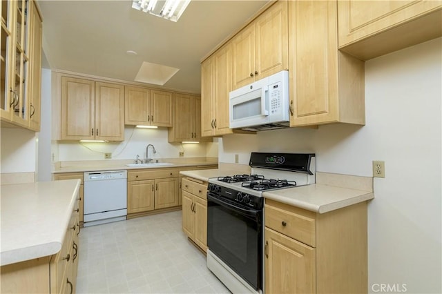 kitchen with sink, light brown cabinetry, and white appliances