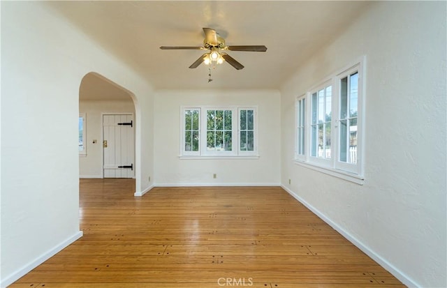 spare room featuring plenty of natural light, ceiling fan, and light hardwood / wood-style flooring