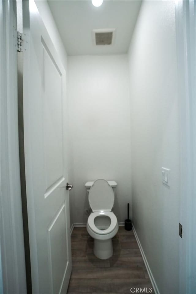 bathroom featuring hardwood / wood-style floors and toilet