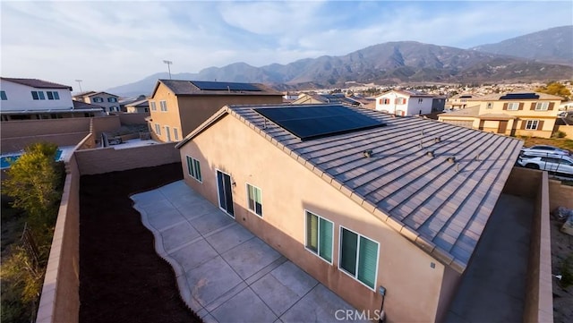 view of side of home with a mountain view and solar panels