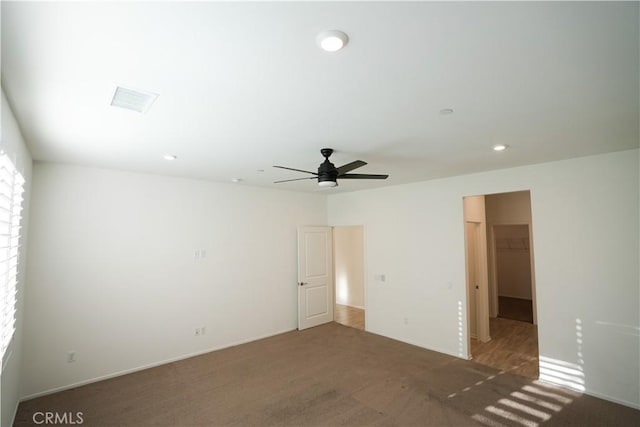 carpeted spare room featuring ceiling fan