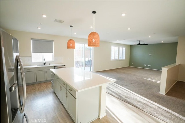 kitchen featuring sink, gray cabinetry, hanging light fixtures, a center island, and stainless steel refrigerator with ice dispenser