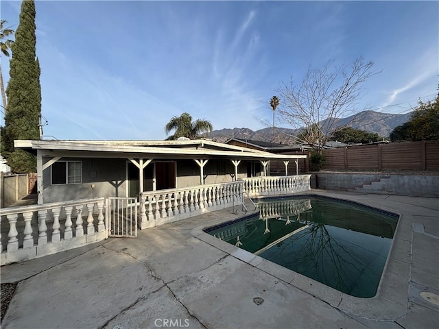 view of swimming pool with a mountain view and a patio area