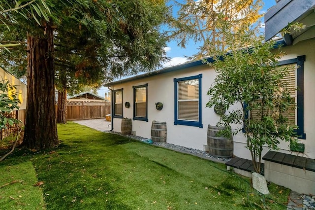 view of property exterior featuring a lawn and a patio area