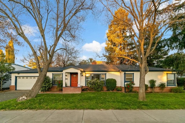 ranch-style home featuring a garage and a front yard