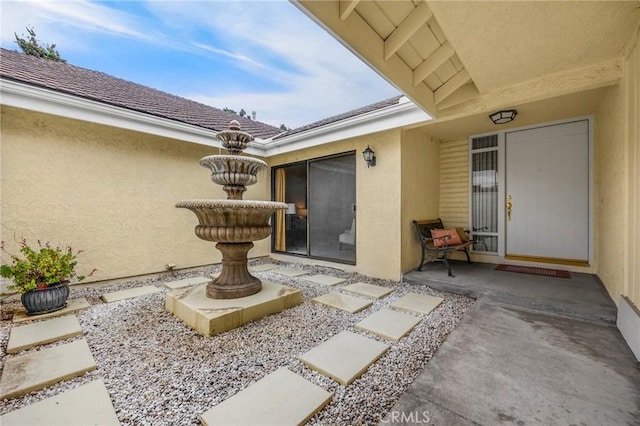 view of exterior entry featuring a patio